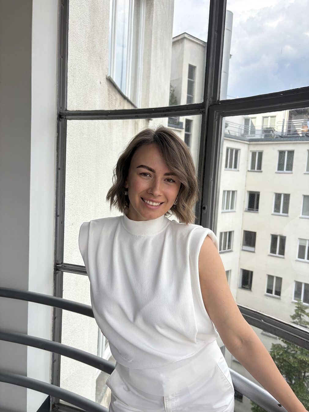 Guest with a short brown bob on the salon balcony